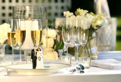 Cake figurines on dinner plate  at wedding reception