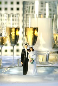 Wedding cake figurines on plate at dinner reception