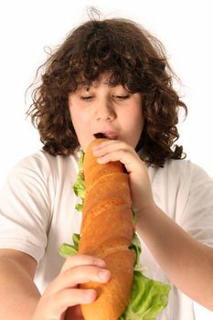 boy eating large sandwich on white background