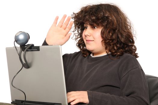boy using laptop, waving hand of a webcam