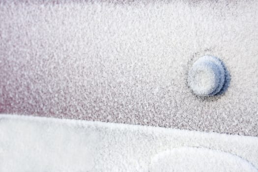 Keyhole on a cardoor completely covered with frost after a winter blizzard