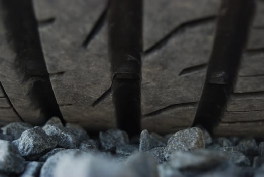 closeup of a car tire profile (car parked on pebbles)