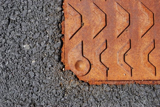 part of a rusty gully on concrete pavement