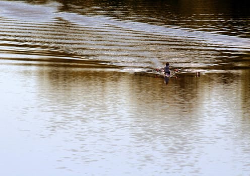 A kayakers skimming across the river.
