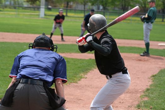 A batter crouches awaiting the pitch.