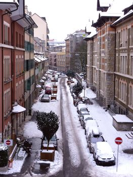 Geneva snowy street by winter with cars and buildings