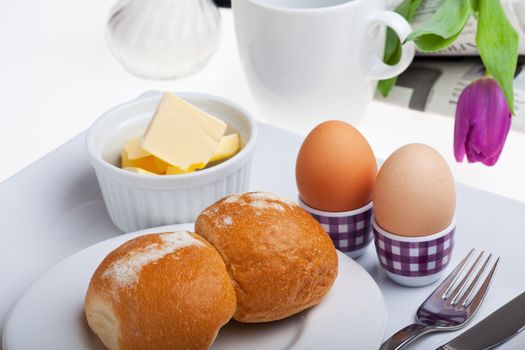 eggs, bun, butter and coffee on white background