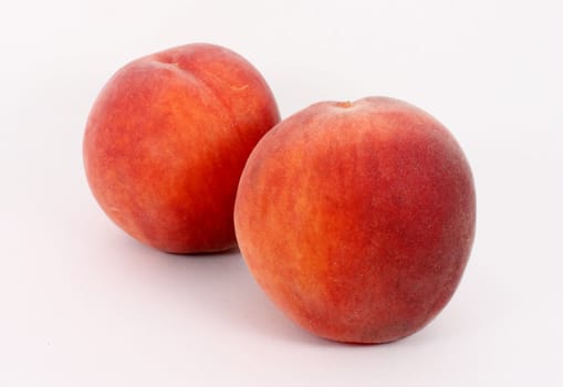 Two fresh ripe peaches, isolated