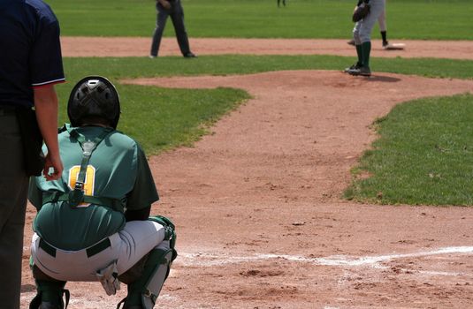 A shot from behind home plate, showing the catcher waiting for the pitch.