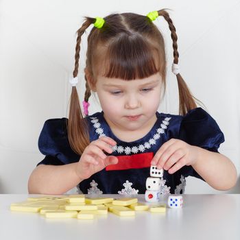 A child playing with small toys, sitting at the table