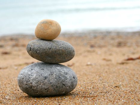 3 stones stacked up on beach