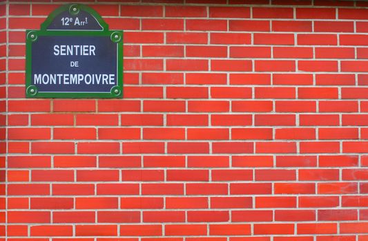 Bricks wall in Paris with the name of the street and large empty space for your adds