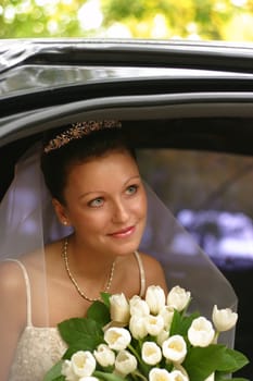 Beautiful the bride with a bouquet in the automobile