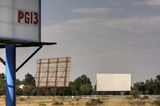 Drive in movie theater with two screens and PG13 film rating sign somewhere in the southwest. HDR image. Copy space.