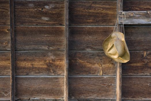 straw cowboy hat on the old barn wall  - weathered wood background
