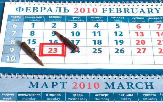 Calendar with date on February, 23rd, day of the defender of fatherland to Russia, and cartridges on a white background.