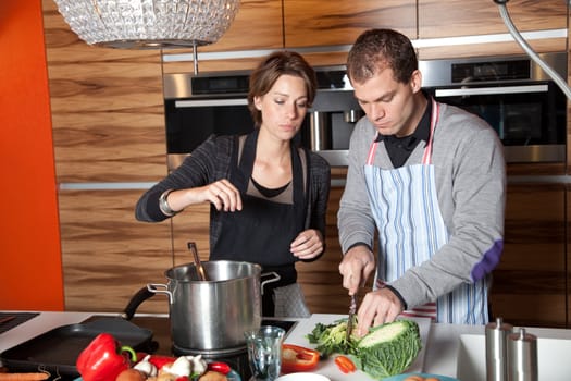 Cute young couple working together in the kitchen