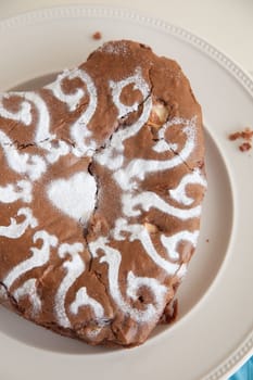 Delicious heartshaped chocolate cake with icing sugar pattern on top
