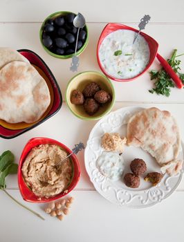 Delicious table filled with snack such as homemade pita, tzatziki, hummus and falafel