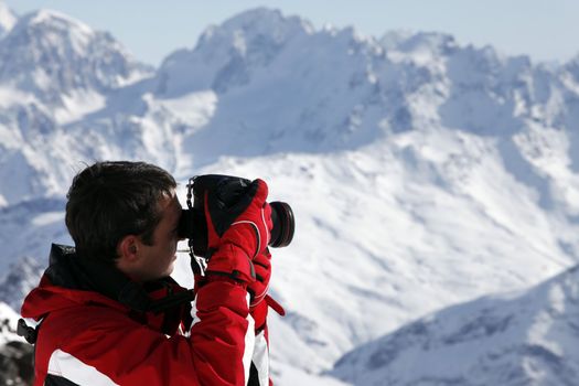 The photographer works on a background of mountains of Elbrus