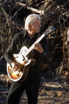 Electric Gutiar Player in Front of a Big Pile of Wood