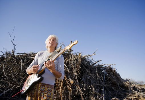 Electric Gutiar Player in Front of a Big Pile of Wood
