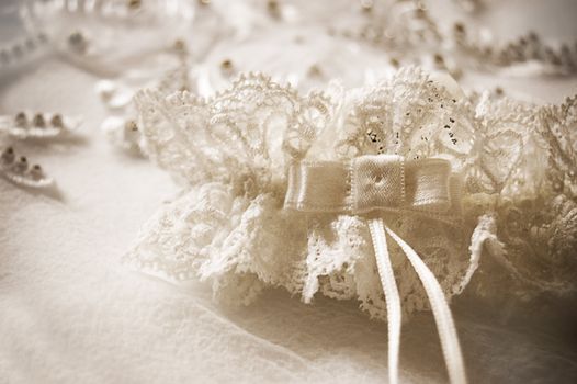 Wedding garter on lace in sepia