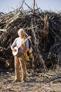 Barefoot banjo Player in Front of a Big Pile of Wood