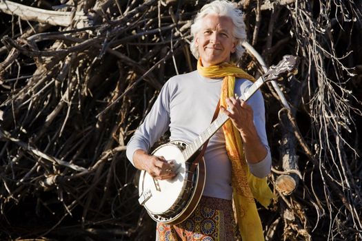 Banjo Player in Front of a Big Pile of Wood