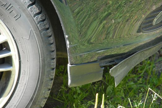 The car's owner has hit an edge with the front of the car, damaging some of the blue coating as well as a piece of the car.