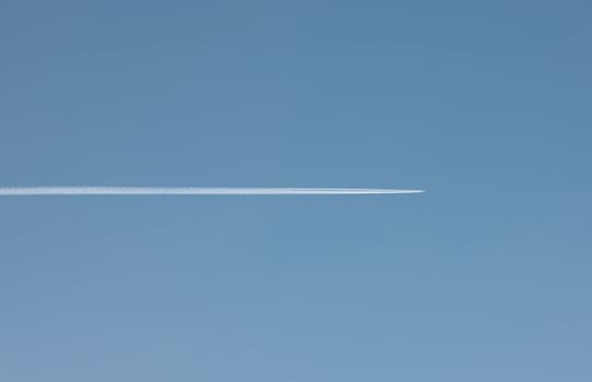 Commercial Jet leaving vapor trail on a clear blue sky