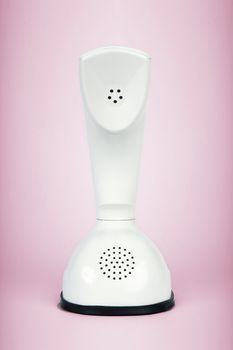 Stylish retro telephone from the sixties isolated on pink background