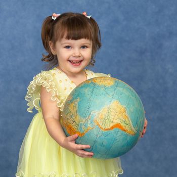 Beautiful little girl with the geographic globe