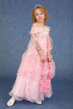 Beautiful little girl in a pink dress on a blue background