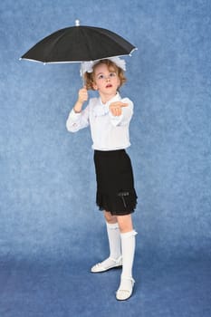 Girl with an umbrella under imaginary rain in studio
