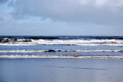 the waves crashing in on ballybunion beach ireland during winter