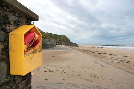 a rescue buoy at ballybunion beach in ireland on a cold deserted winters day