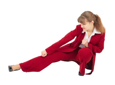 A woman in a red business suit kicks