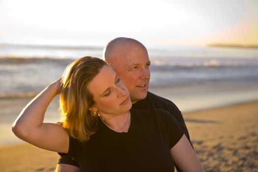 Young couple holding each other at the Beach at Sunset