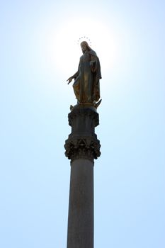 Statue of the Blessed Virgin Mary near cathedral in Zagreb, Croatia, with sun in background