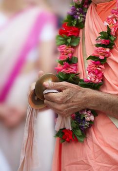 Photo of hands of the Buddhist. Play on musical plates.