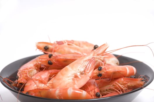 close up on a bowl of raw and fresh shrimps, isolated on white