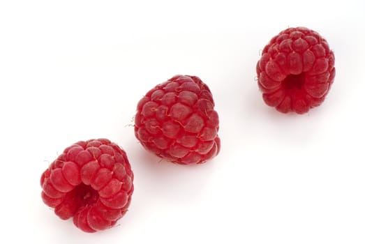 Three raspberry on white background. Close up.