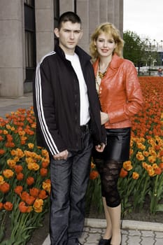 Young family against yellow and red tulips