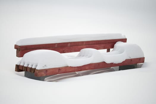 close-up lonely bench covering with white snow