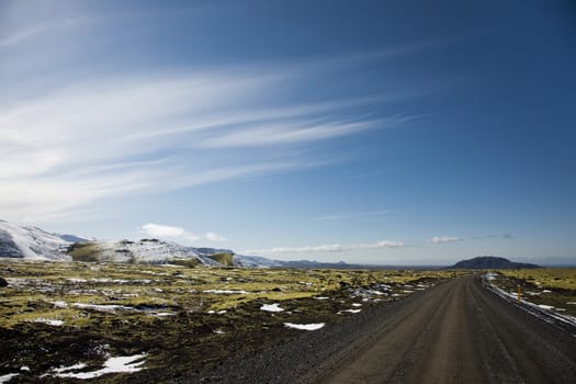 isolated road going through unspoiled landscape in the spring