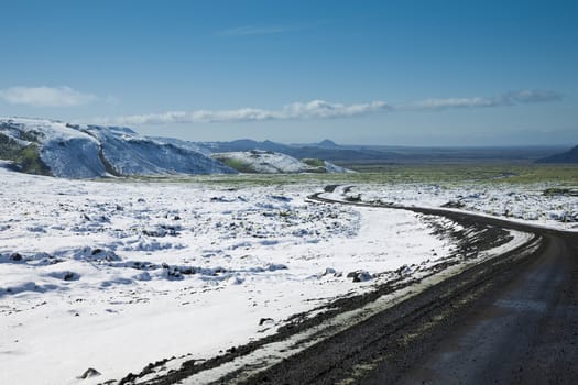 isolated road going through unspoiled landscape in the spring