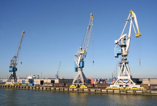 Harbor cranes, containers and train cars on a dock in Rotterdam