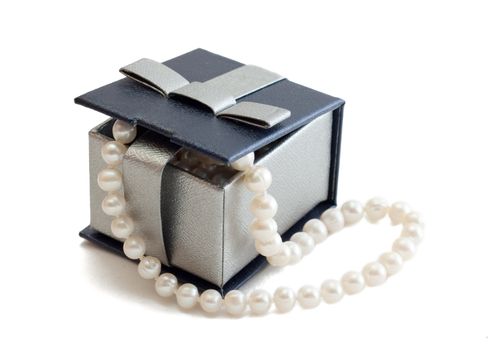 A string of pearls in a box on white background