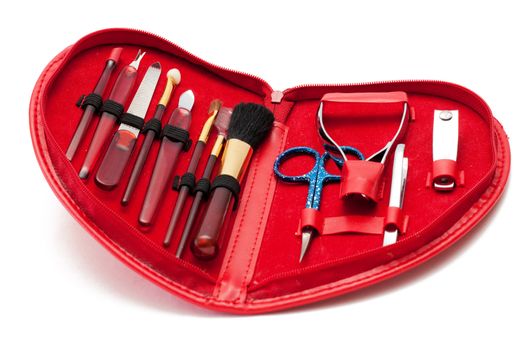 Manicure set in red heart-shaped bag over white background